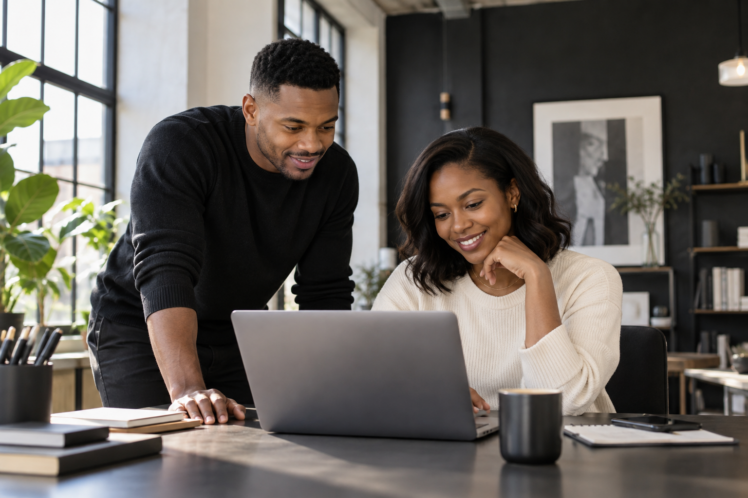 Black creative professionals collaborating over a laptop